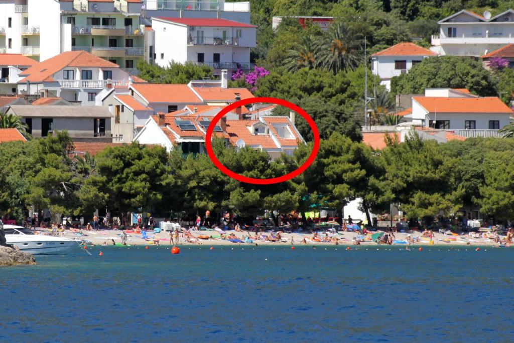 un círculo rojo en una playa con un grupo de personas en Studio Drvenik Donja vala 6658a, en Drvenik