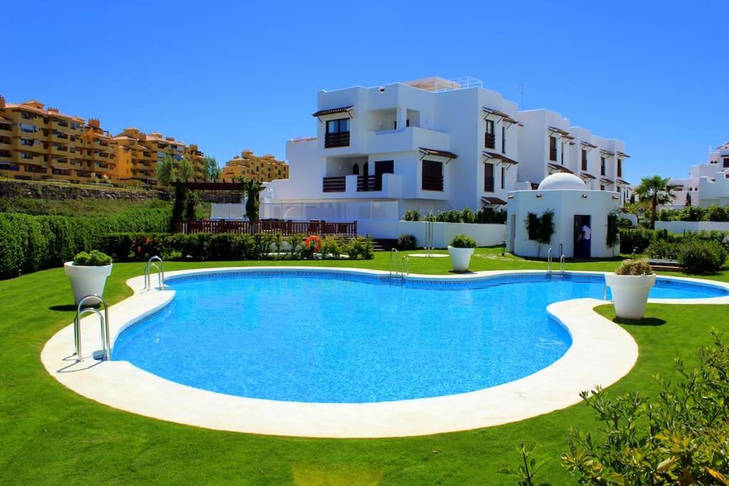 uma villa com piscina em frente a uma casa em Luxury apartment in Golf Hills, Estepona. em Estepona