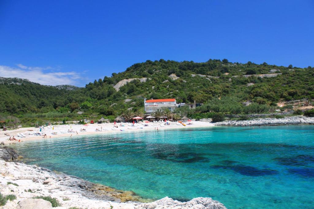 a beach with a bunch of people in the water at Rooms by the sea Hvar - 8785 in Hvar