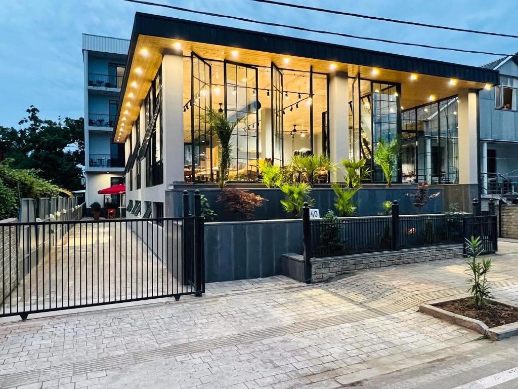 a home with a black fence and a building at Level Up Hotel & Restaurant in K'obulet'i