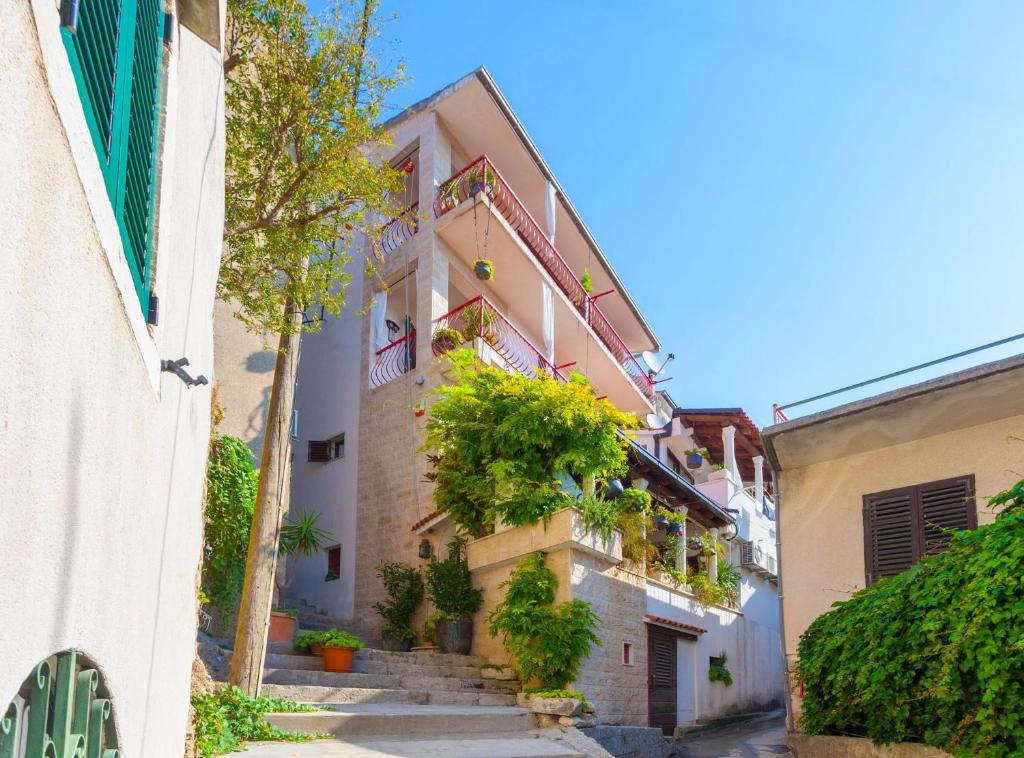 un callejón con escaleras y plantas en un edificio en Studio Makarska 11063c, en Makarska