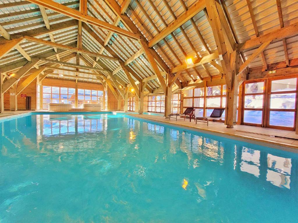 une grande piscine intérieure dans un bâtiment dans l'établissement Madame Vacances Residence Les Fermes de Saint Sorlin, à Saint-Sorlin-dʼArves