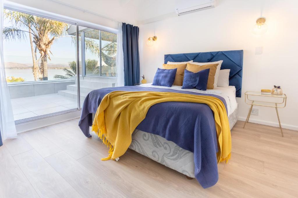 a bedroom with a bed with blue and yellow sheets at Waterfront Serenity View in Hartbeespoort