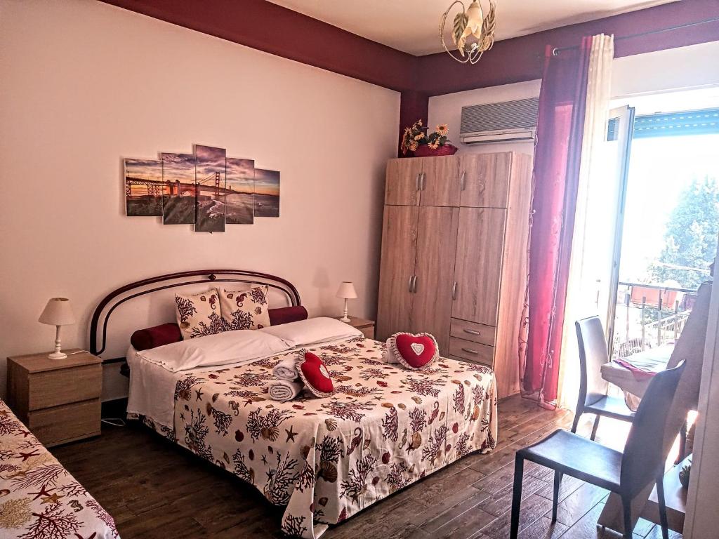 a bedroom with a bed with two red pillows on it at B&B Antonella in Taormina