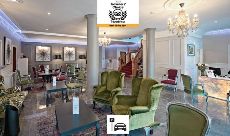 a lobby with green chairs and tables and a chandelier at Brook Lodge Boutique Hotel in Killarney