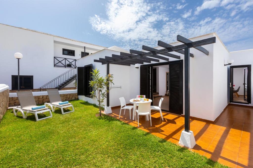 a patio with a table and chairs in a yard at Los Cardones Boutique Village in Playa de las Americas