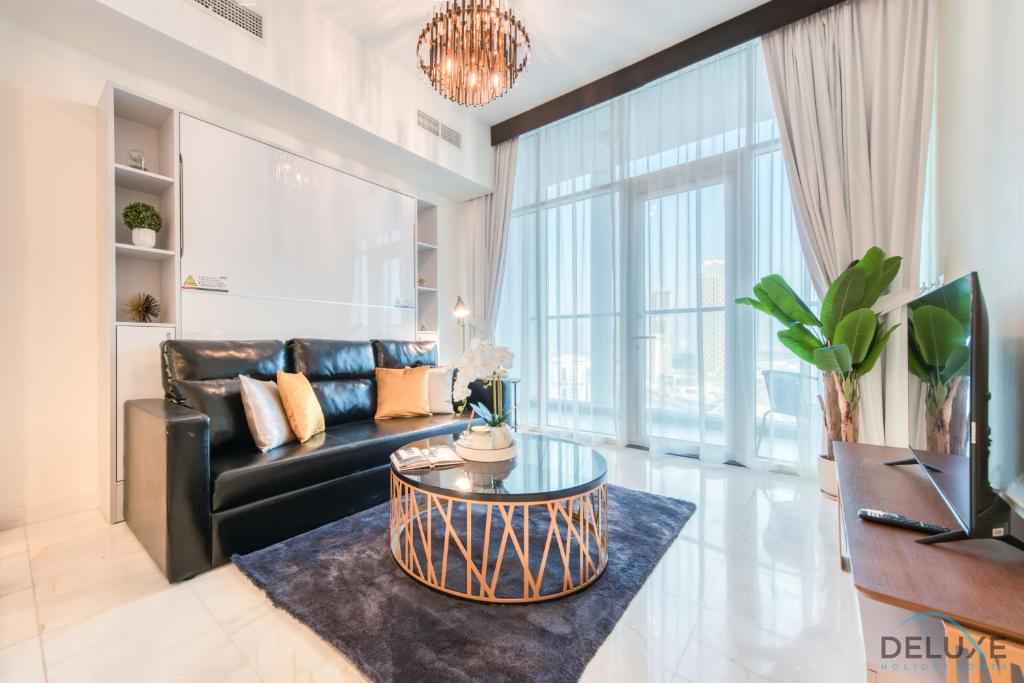 a living room with a black couch and a table at Classy 1BR at Bayz by Danube Business Bay by Deluxe Holiday Homes in Dubai