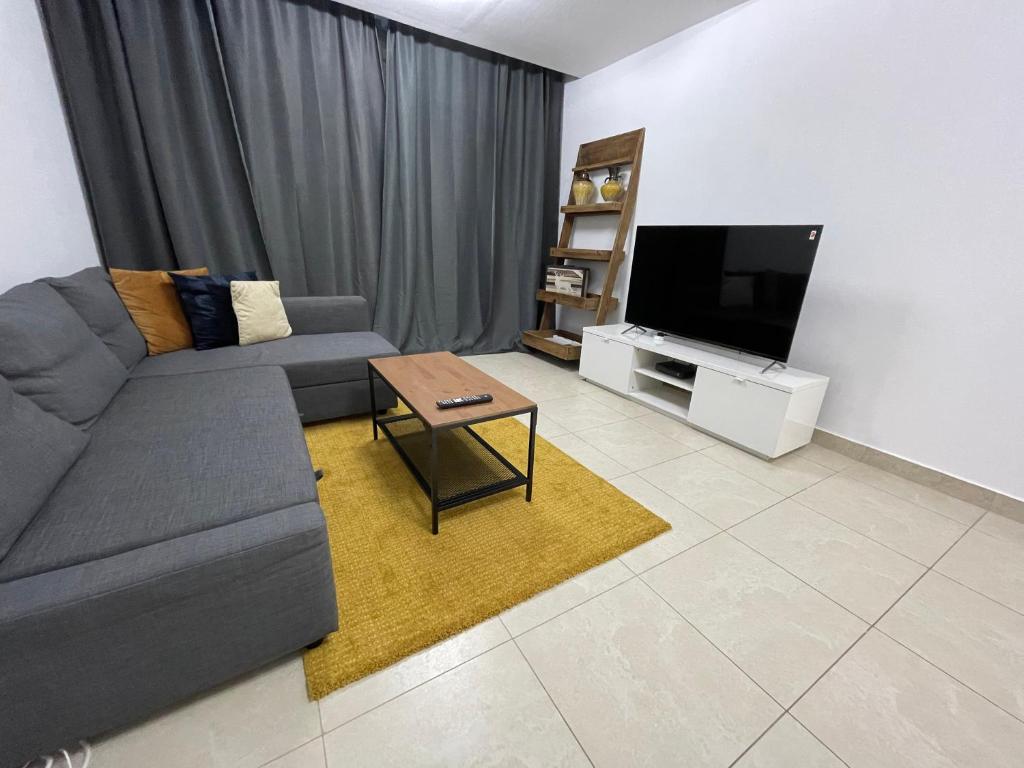 a living room with a couch and a flat screen tv at [METRO] Premium Location Lovely 2 Bedroom In JLT in Dubai
