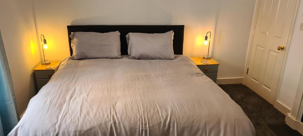 - une chambre avec un lit et deux lampes de chaque côté dans l'établissement Fore Street Bodmin, à Bodmin