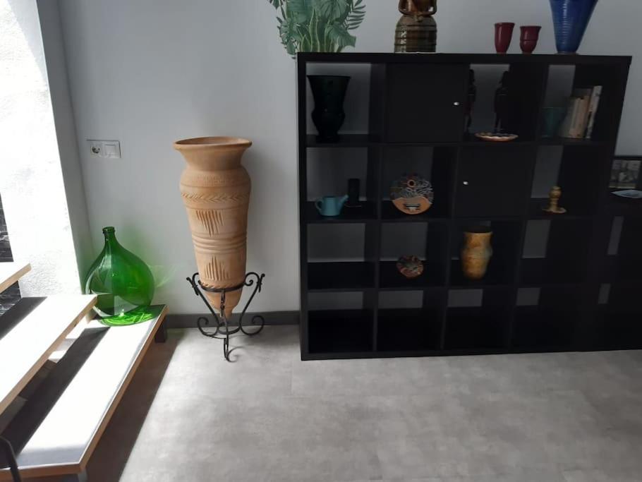 a living room with a black shelf with vases on it at Casa llena de vida con patio y terraza in Coín