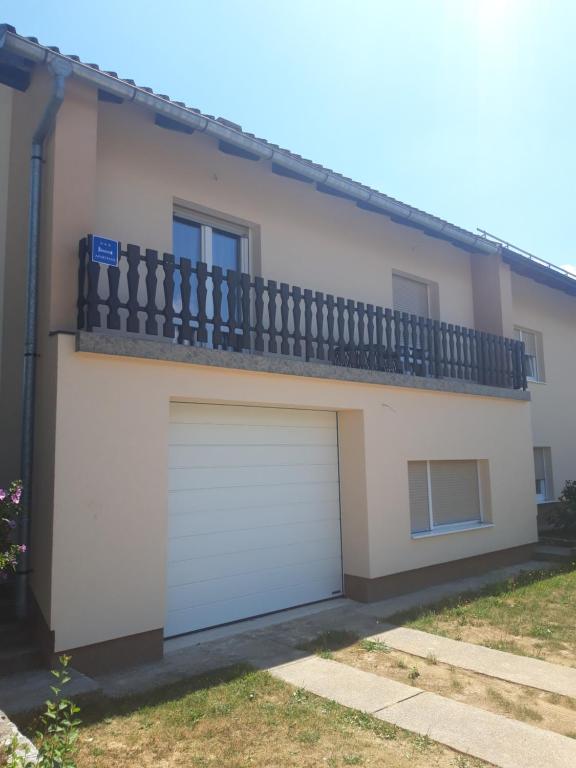 ein Haus mit zwei Garagentüren und einem Balkon in der Unterkunft Matea in Gospić
