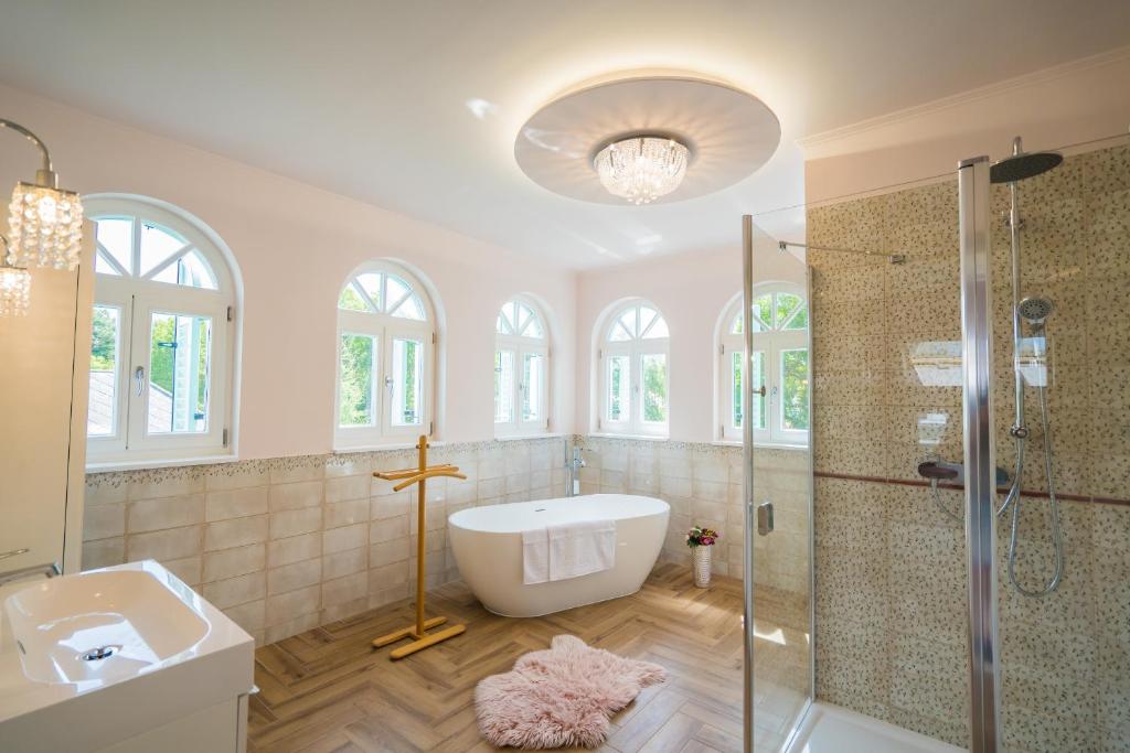een badkamer met een bad, een douche en een wastafel bij Harmony Boutique Villa in Siófok