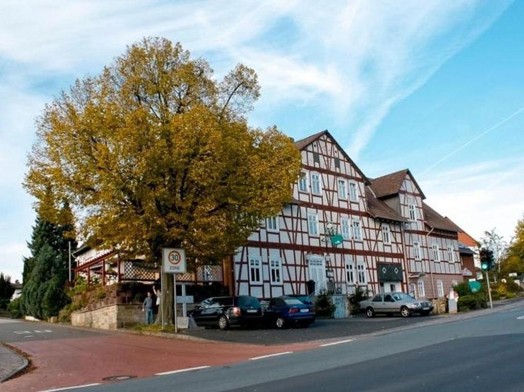 um grande edifício com carros estacionados em frente em Ehlener Poststuben em Habichtswald