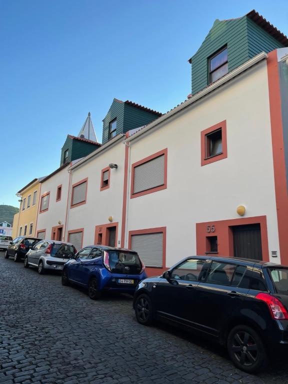 a row of cars parked in front of buildings at A Casa da Maria in Horta