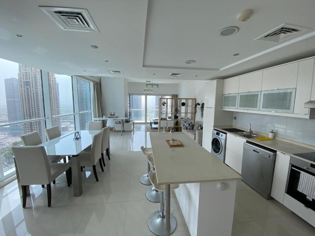 a kitchen with a table and chairs and a dining room at One bedroom apartment with pool & gym near Marina in Dubai