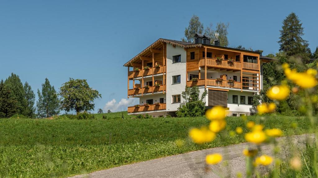 un edificio con balcones junto a un campo en Im Wiesengrund Apartments en Sesto