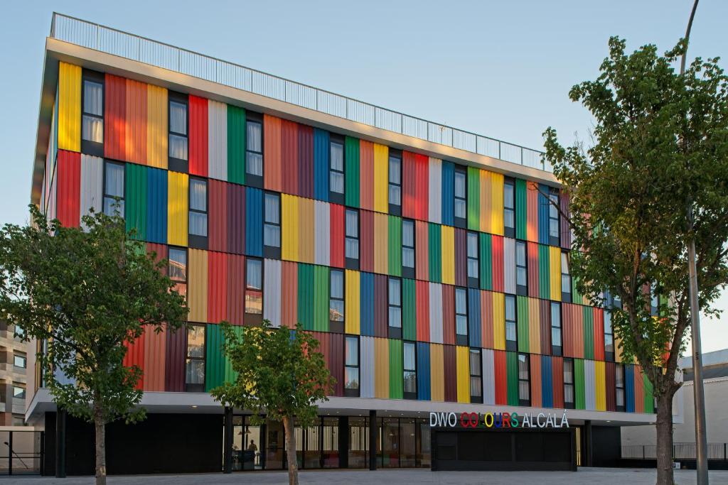 un edificio con una fachada colorida con árboles delante en DWO Colours Alcalá, en Madrid