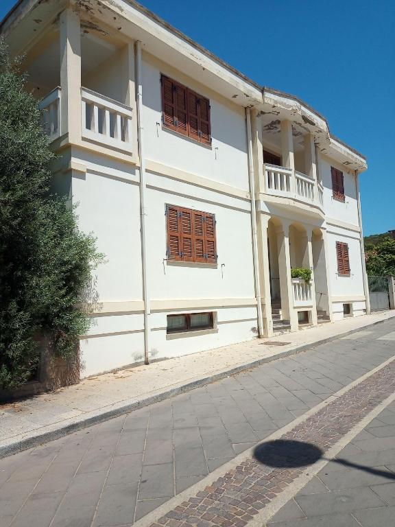 a white building with windows on a street at Il Salvatore in Masainas