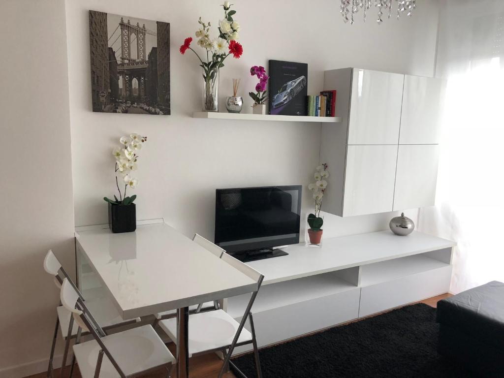 een woonkamer met een wit bureau en een tv bij Your best apartment in Abano Terme in Abano Terme