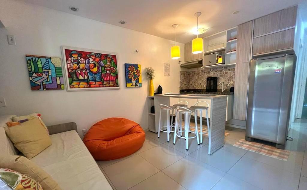 ein Wohnzimmer mit einem Sofa und einer Küche in der Unterkunft Ap Studio 230 Eco Paradise in Cumbuco