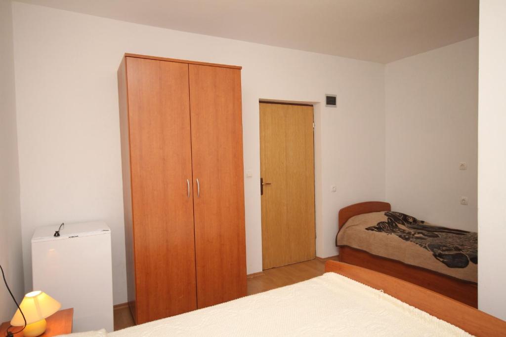 sypialnia z drewnianą szafką i łóżkiem w obiekcie Triple Room Metajna 4120e w mieście Metajna