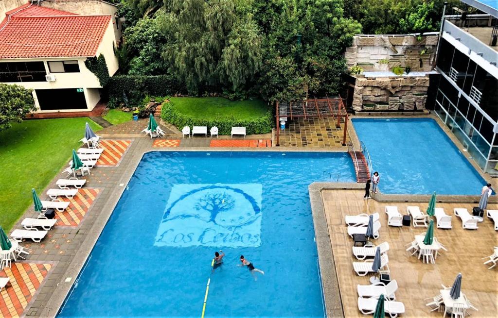 an overhead view of a pool with two people swimming at Hotel Los Ceibos in Tarija