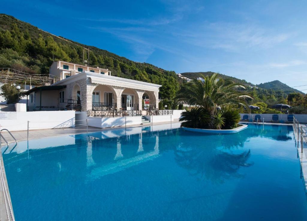 duży basen z niebieską wodą przed budynkiem w obiekcie Sunset Premium Studio 2 w mieście Agios Nikitas