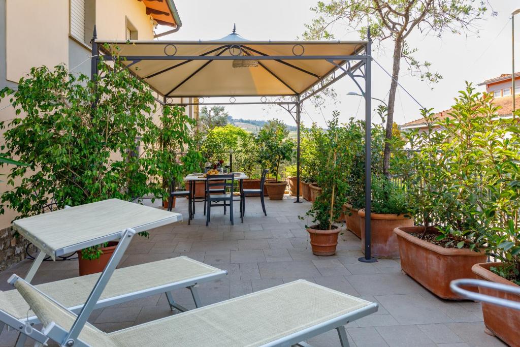 une terrasse avec une table, des chaises et un parasol dans l'établissement Casa Vacanze Alessandro 1, à Greve in Chianti