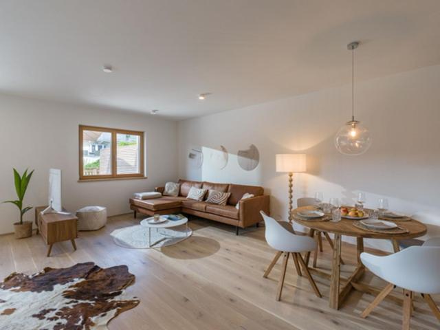 ein Wohnzimmer mit einem Sofa und einem Tisch in der Unterkunft Apartment Hideaway - Stylisch, ruhig, Topausstattung, Infrarotsauna, Dachterrasse in Walchsee