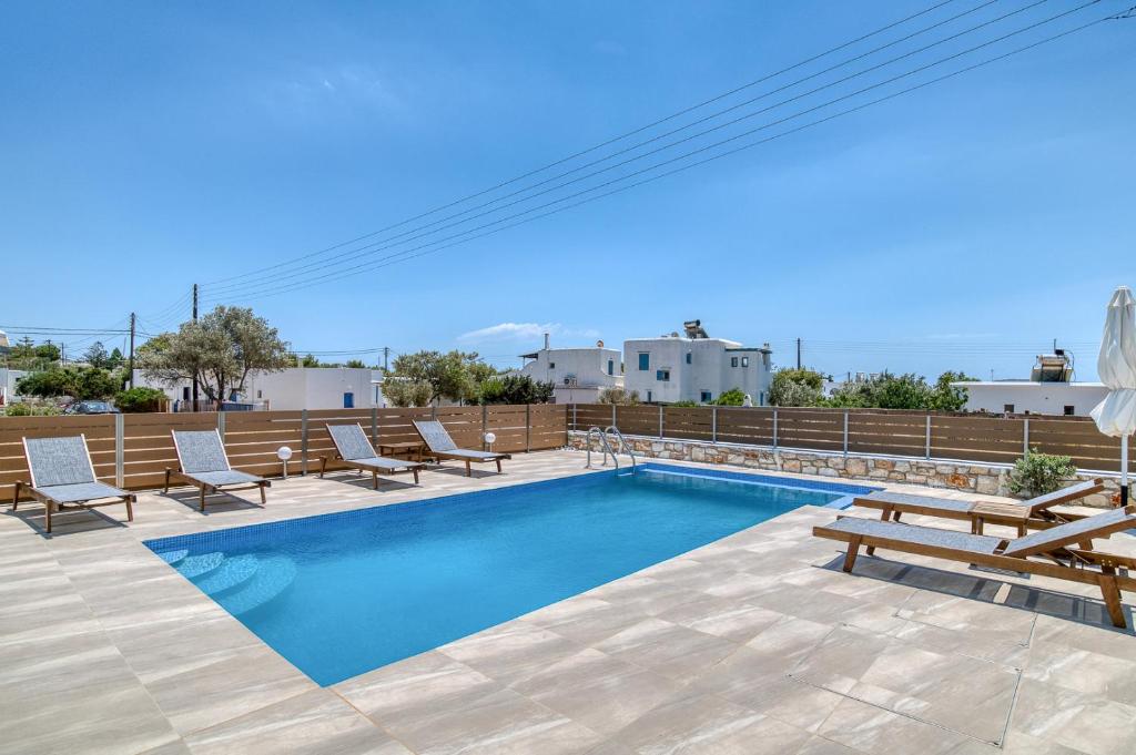 een zwembad met ligstoelen en een zwembadvisor bij Ippocampos Seaside Serenity - Unwind at Paros Poolside Retreats in Aliki