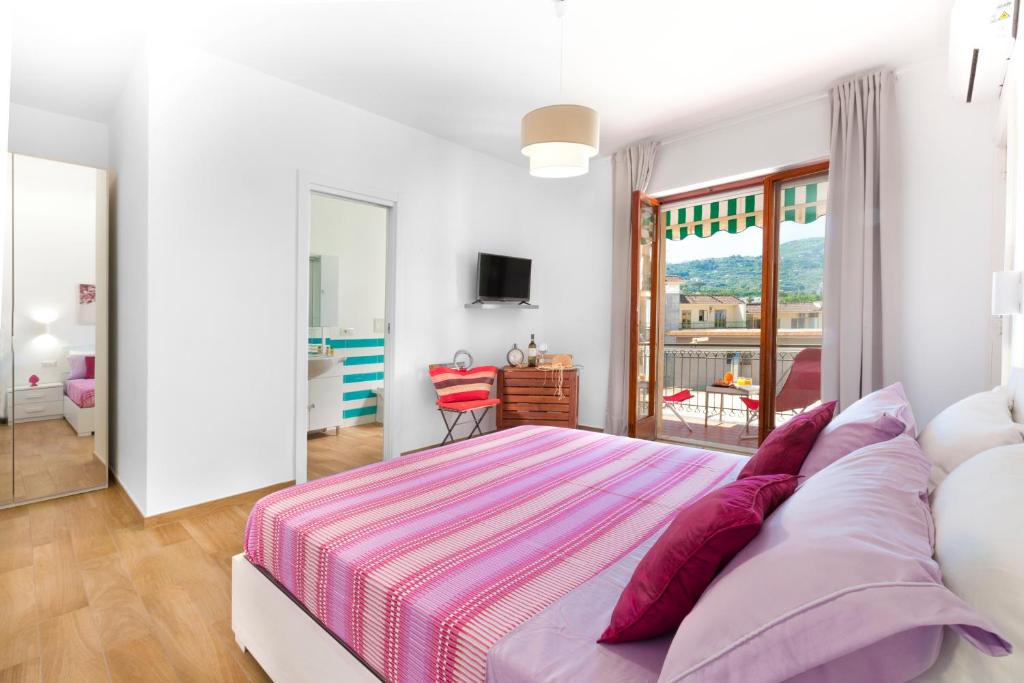 1 dormitorio con 1 cama grande y balcón en Estate4home - SOFIA FLORA, en Piano di Sorrento