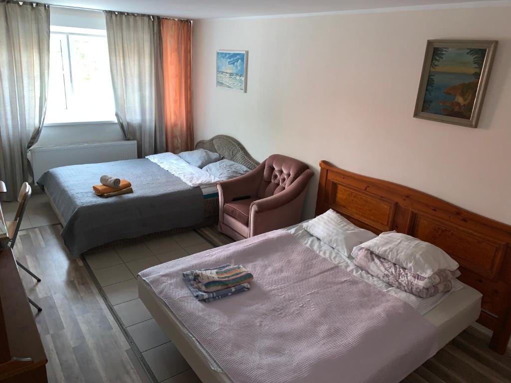 um quarto de hotel com duas camas e uma cadeira em K65, Nice 1-bedroom apartment - 2 big beds em Tartu