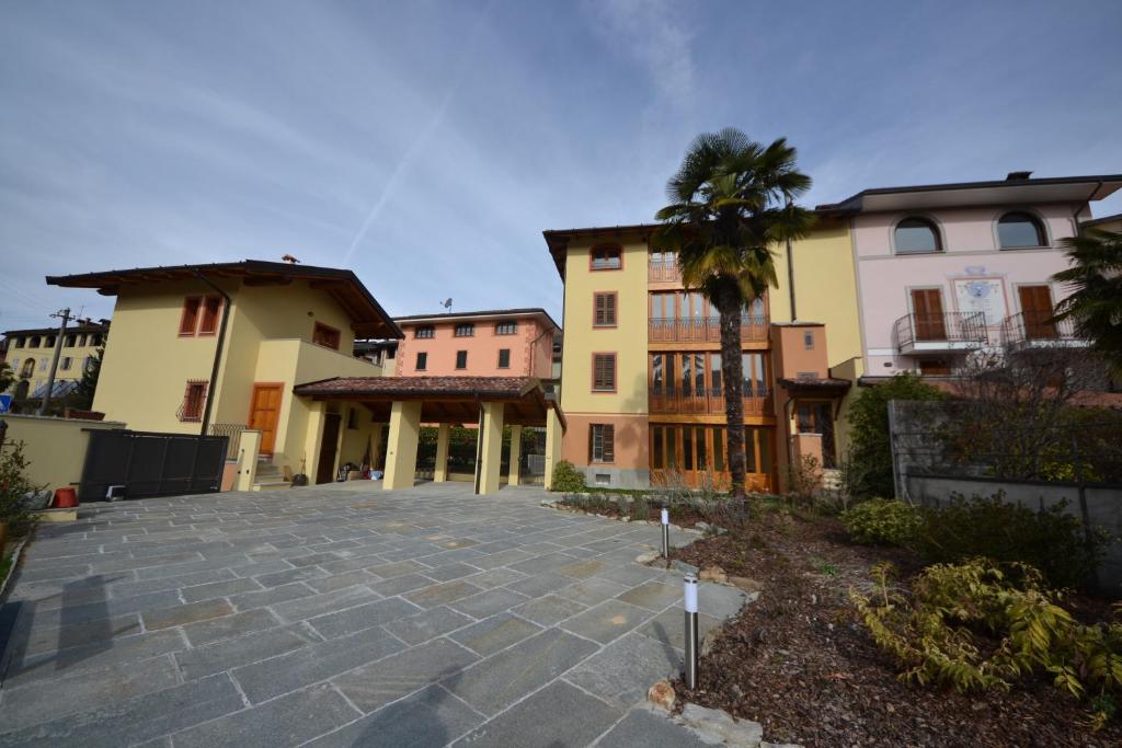 a group of buildings with a courtyard with a palm tree at alla piana in Varallo