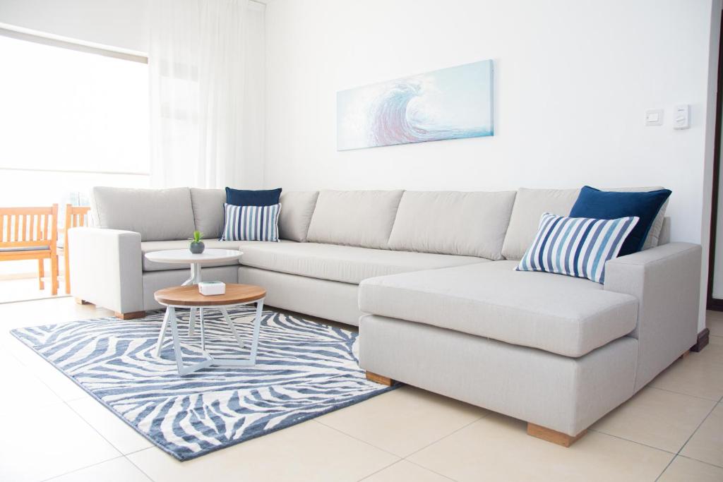 uma sala de estar com um sofá branco e uma mesa em Entire Apartment in Tamarin Riviere Noire em Tamarin