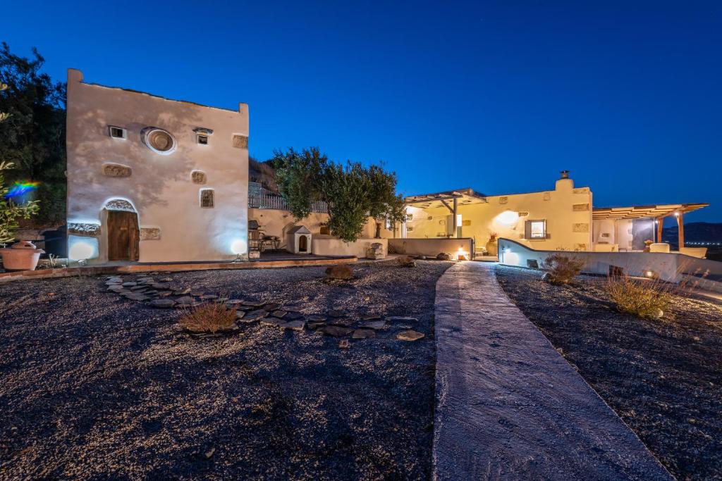a house with a stone path leading to a building at Olive Cottage in Zefiría