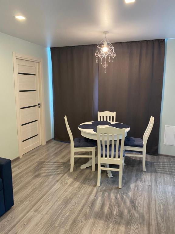 a dining room with a table and chairs and a chandelier at Hygge apartment Narva in Narva