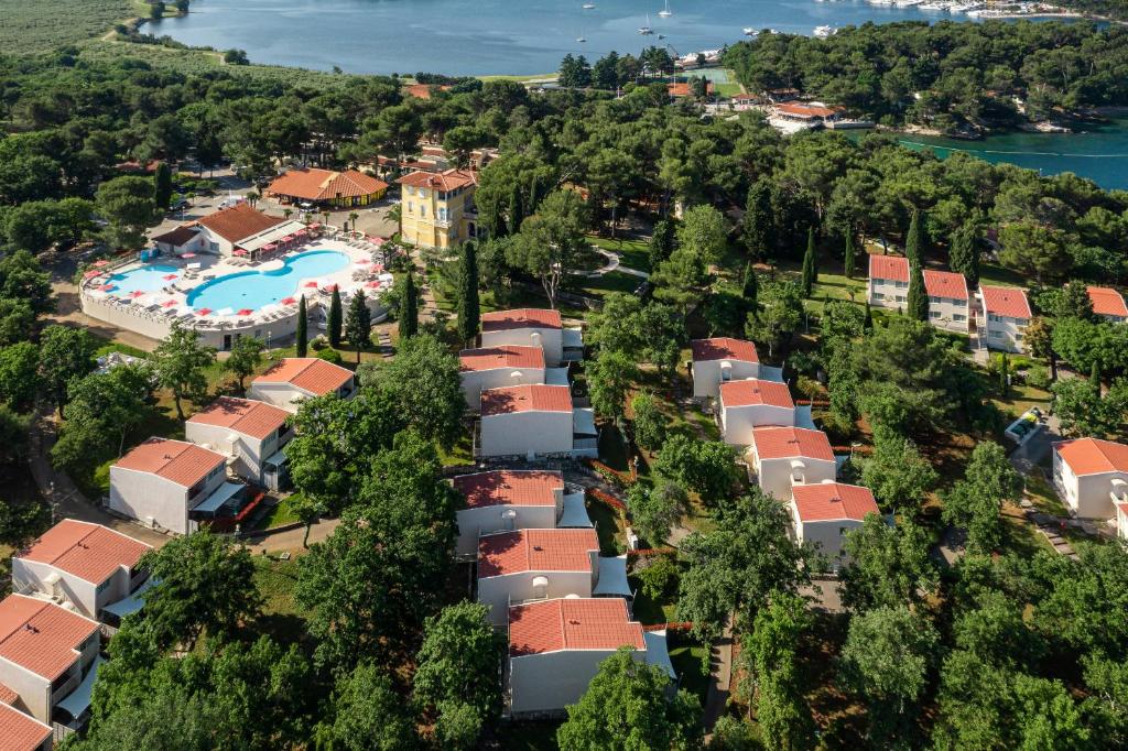 eine Luftansicht eines Resorts mit Pool und Bäumen in der Unterkunft Apartments Bellevue Plava Laguna in Poreč