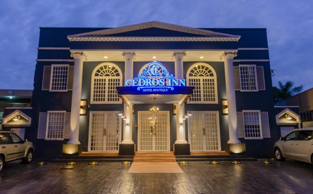 ein blaues Gebäude mit einem Schild, das den ersten Gasthof liest in der Unterkunft Cedros Inn Boutique Hotel in Guayaquil