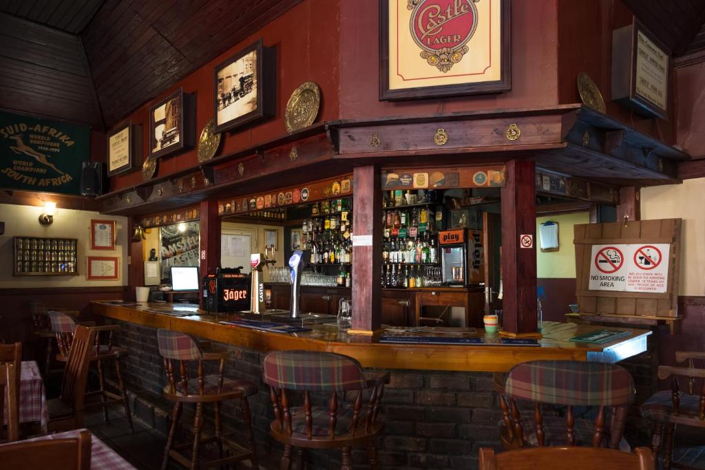 a bar in a pub with chairs around it at Dullstroom Inn in Dullstroom