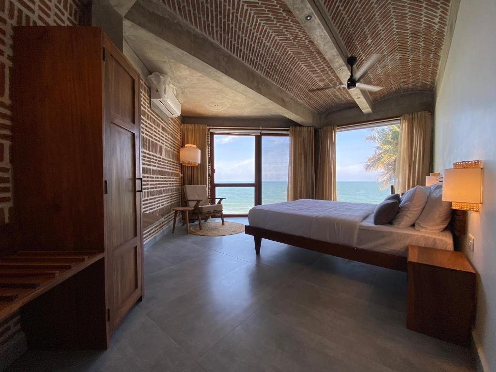 um quarto com uma cama e vista para o oceano em Ostel In em Pondicherry