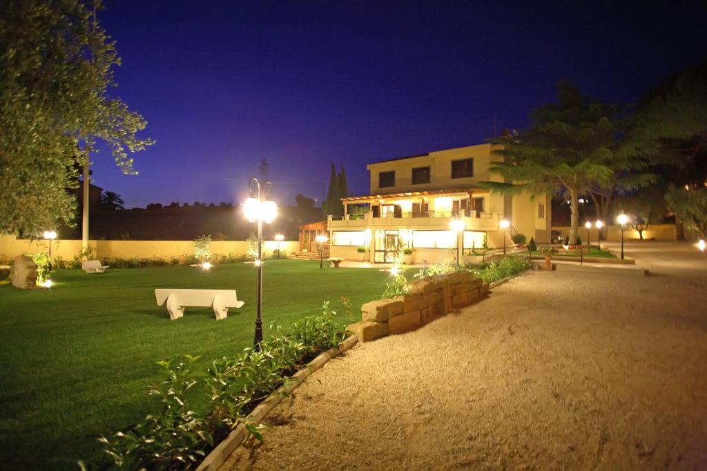 un parco di notte con un divano bianco nell'erba di Bed and Breakfast La Corte degli Ulivi a Civitavecchia