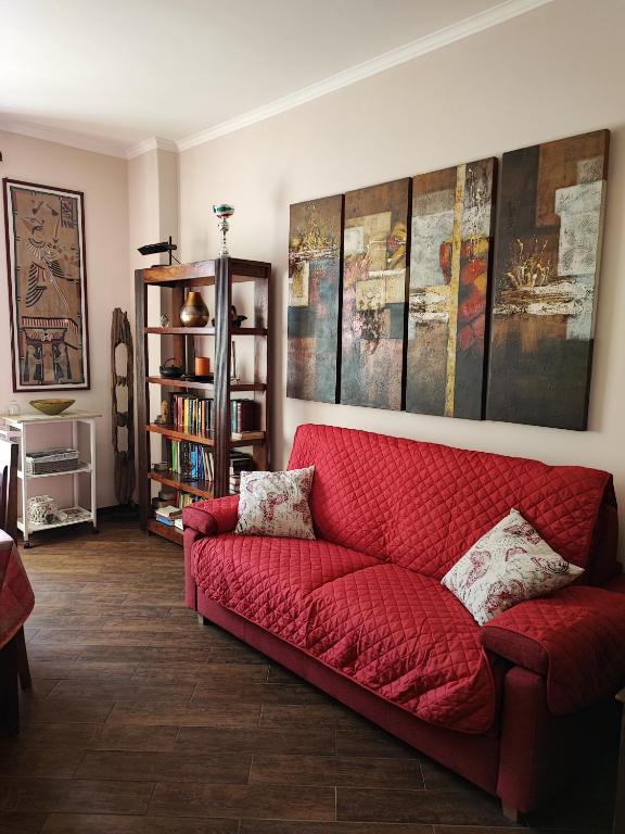 - un salon avec un canapé rouge et une étagère à livres dans l'établissement Casa di Anna, à Rome