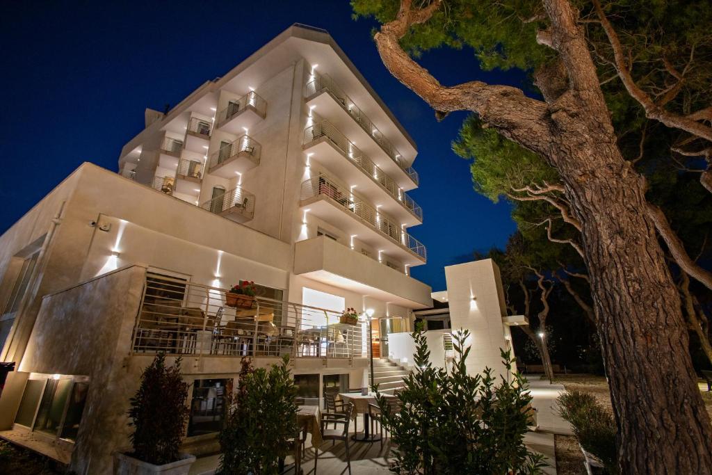 um grande edifício branco com uma varanda à noite em Hotel Velia em Grottammare