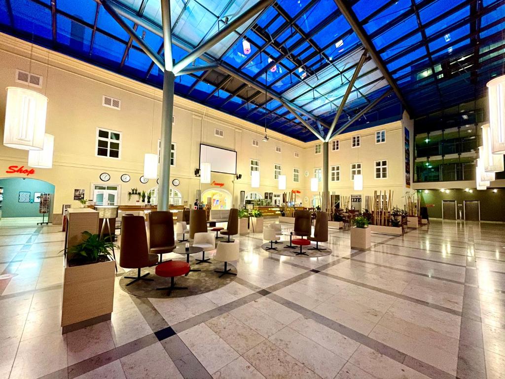 JUFA Hotel Wien City في فيينا: لوبي كبير مع كراسي وطاولات في مبنى