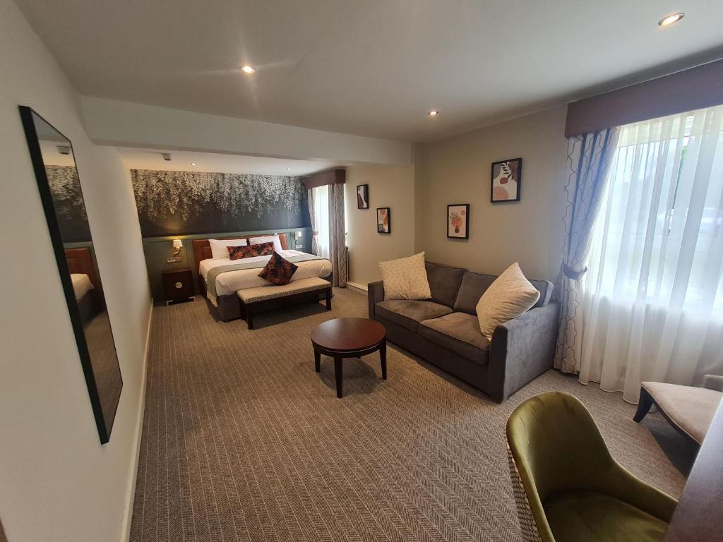 a living room with a couch and a bed at Blue Bell Lodge Hotel in Middlesbrough