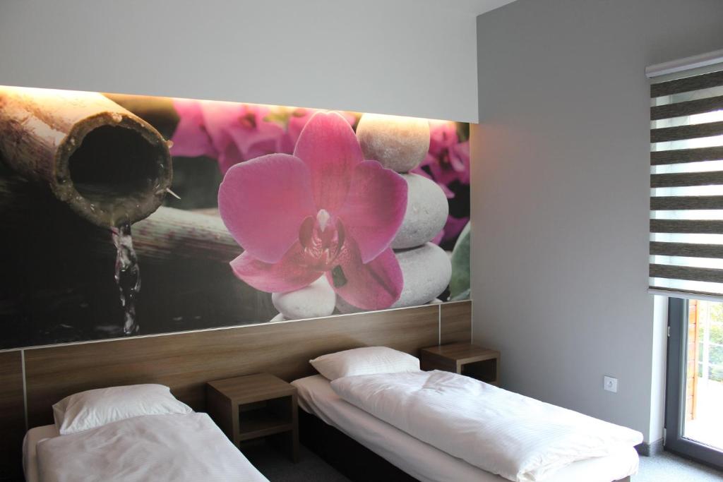 una habitación con 2 camas y una pintura de una flor en Jordaszka, en Wodzisław Śląski