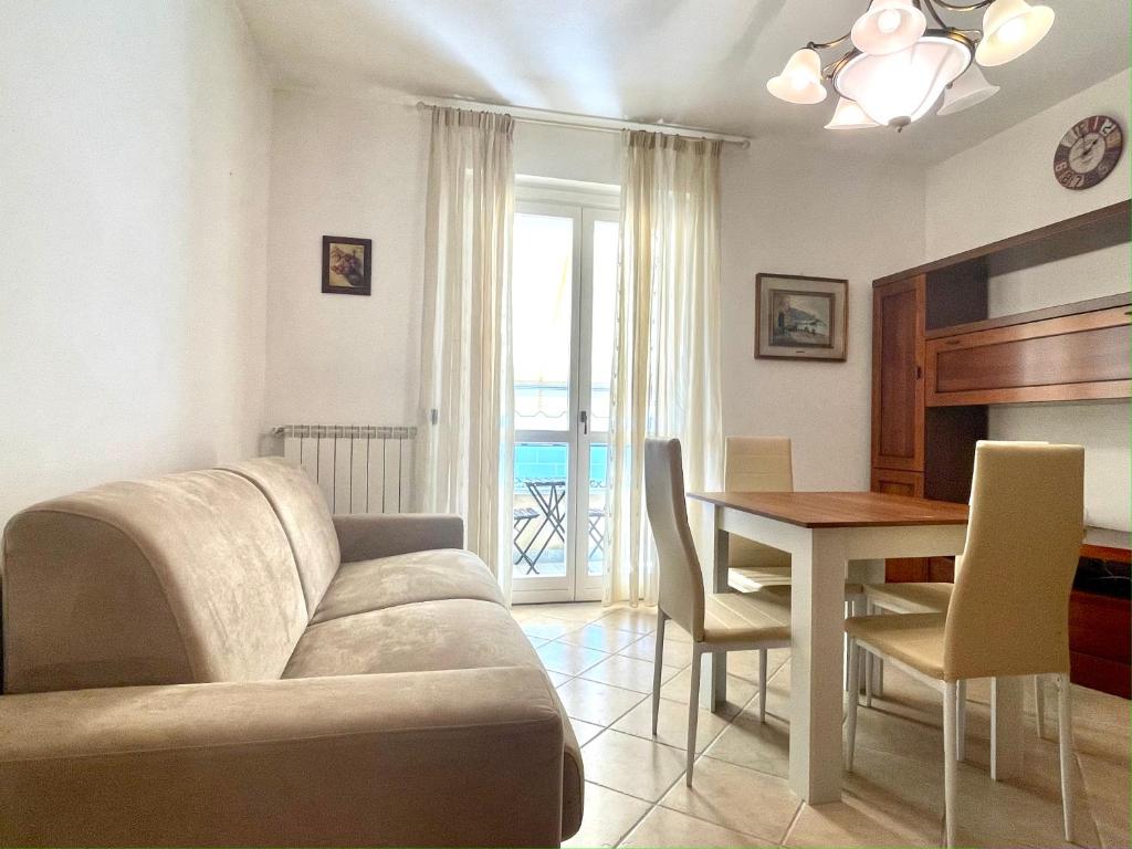 a living room with a couch and a dining room table at Sunset Boutique Apartment in Marina di Massa