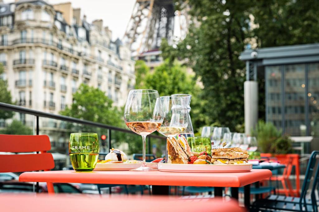 a table with a glass of wine and a plate of food at Pullman Paris Tour Eiffel in Paris