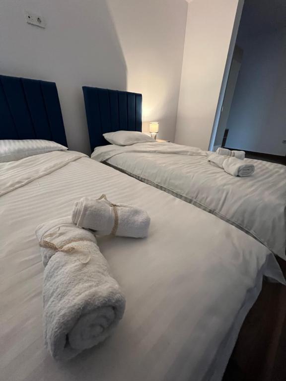 - 2 lits avec des serviettes blanches assises au-dessus dans l'établissement Aparthotel Plevnei2, à Cluj-Napoca