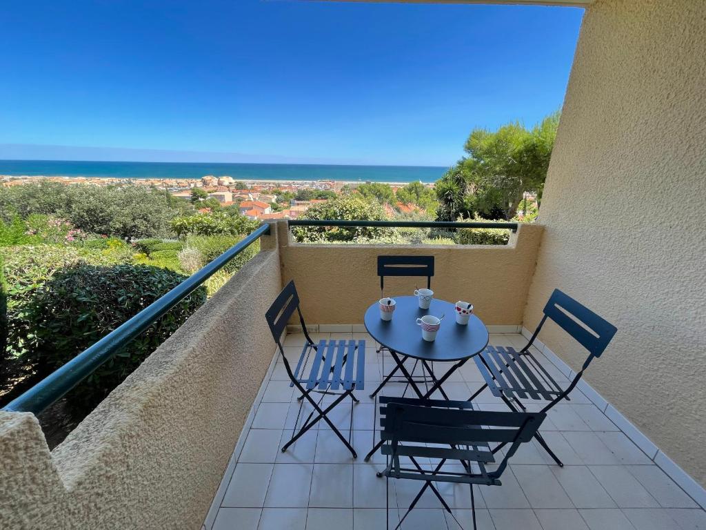 d'un balcon avec une table et des chaises donnant sur l'océan. dans l'établissement Appartement piscine commune Saint Pierre La Mer - 4RH1156, à Saint Pierre La Mer